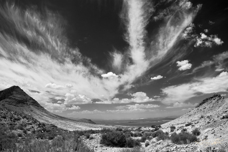 Black and white photograph of mountains in a desert,