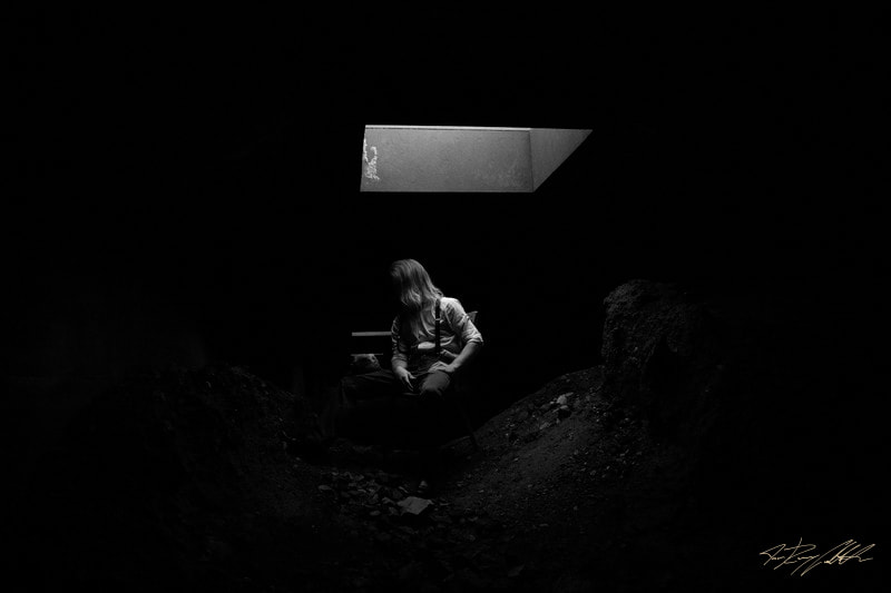 Photograph of landscape portrait in dark tunnel.